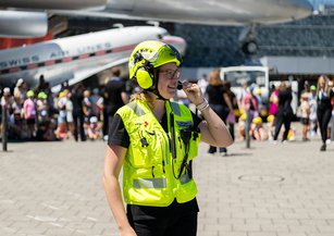 Die Fachperson steht bereit, um den Helikopter einzuweisen.	The specialist is ready to guide the helicopter.