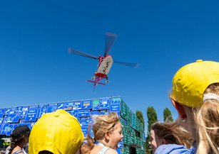Kinder erleben den Abwind des Rettungshelikopters beim Abflug.