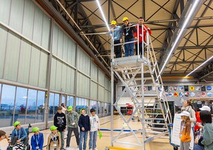 A girl drops an egg from a ladder.