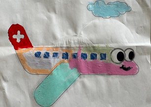 Von einem Kind ausgemaltes Bild eines Rega-Ambulanzflugzeuges mit bunten Farben gestaltet. 