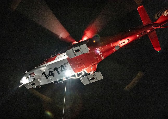 Ein Rettungshelikopter bei einem Nachteinsatz mit der Rettungswinde