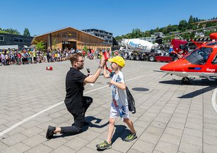 Ein Kind klatscht mit dem Moderator ab.