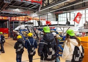 A group of children run through the Rega hangar.