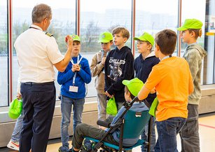 The jet pilot tells a group of children something.