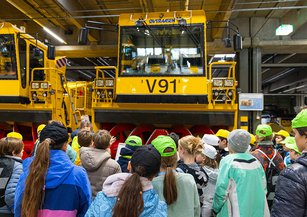 Children marvel at a large snow plough in the hall.