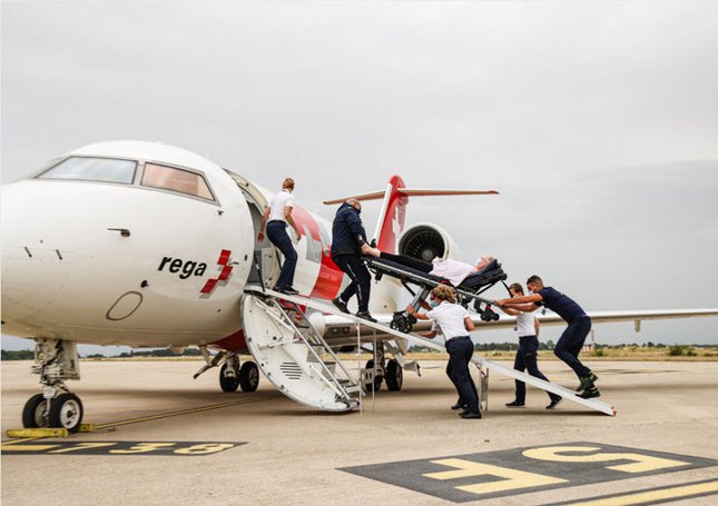 Die Jet-Crew schiebt den Patient auf der Liege in den Jet