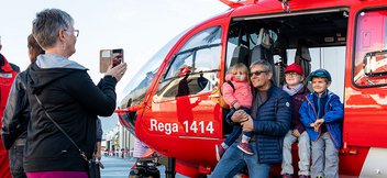 Une famille prend une photo devant l'hélicoptère de sauvetage