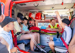 Die Rettungssanitäterin erklärt einer Gruppe von Kindern den Innenraum des Helikopters.