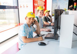 Kinder sitzen bei der Einsatzzentrale und hören den Alarmierungsgesprächen zu.