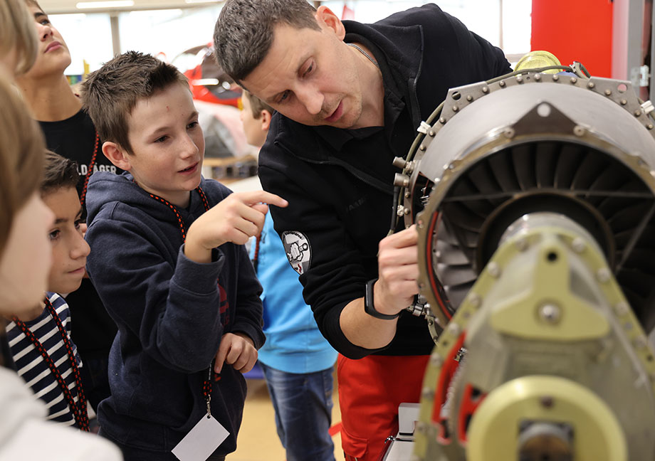 Der Helikoptermechaniker erklärt den Kindern die Mechanik des Rettungshelikopters
